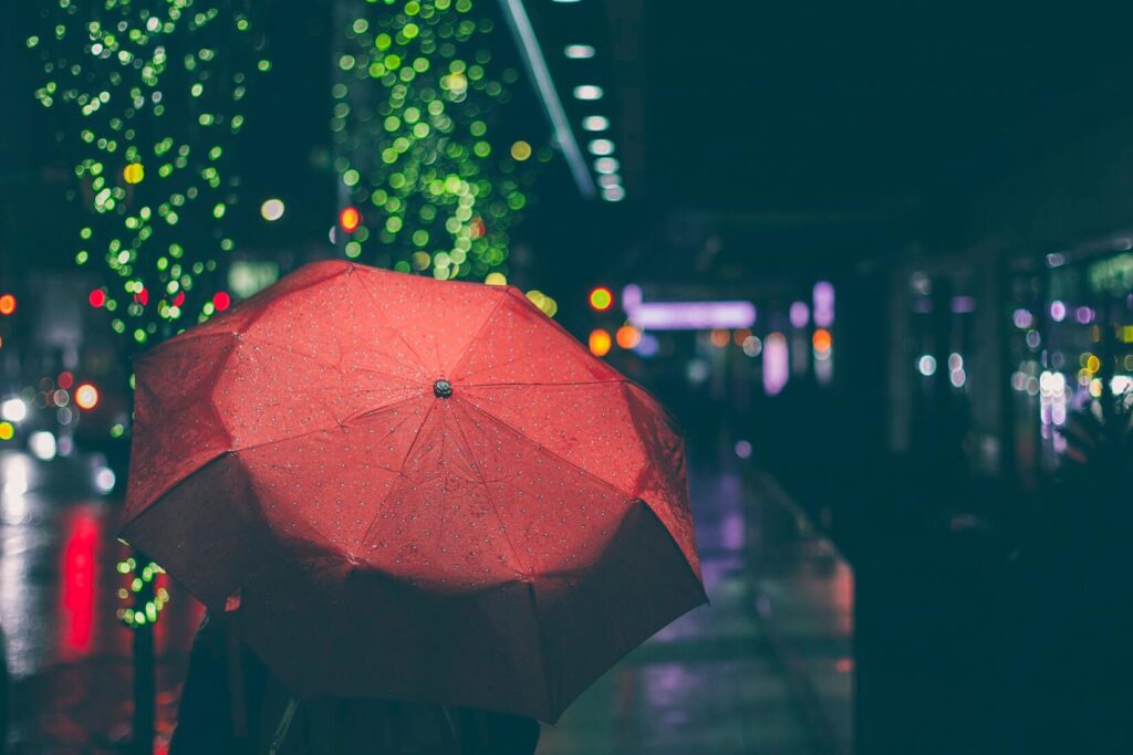 Человек с красным зонтом на ночной улице