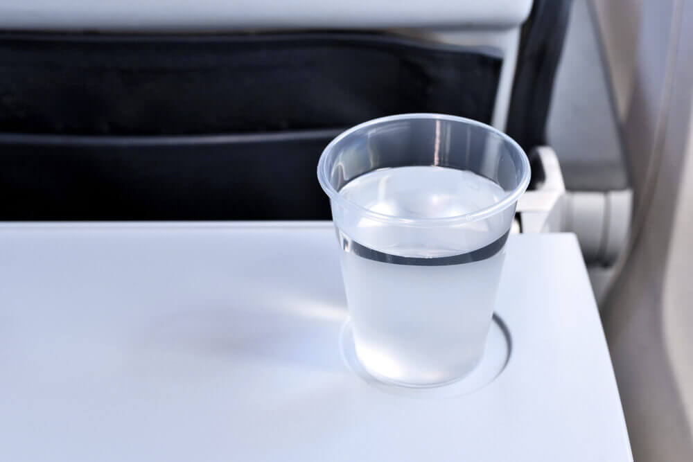 Стаканчик с водой на самолётном столике