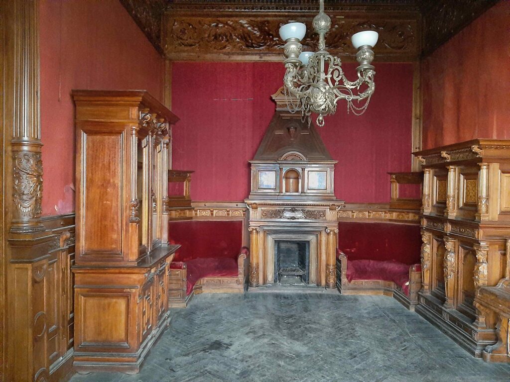 Пустой запылённый каминный зал со старинной мебелью и люстрой