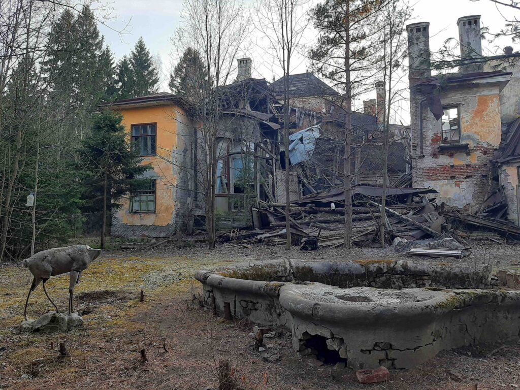 Разрушенный дом с остатками бассейна и статуй