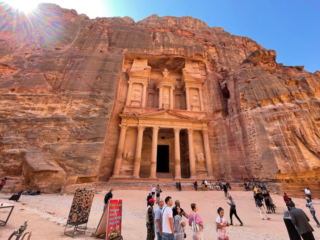 Храм, высеченный в скале, и любующиеся им туристы