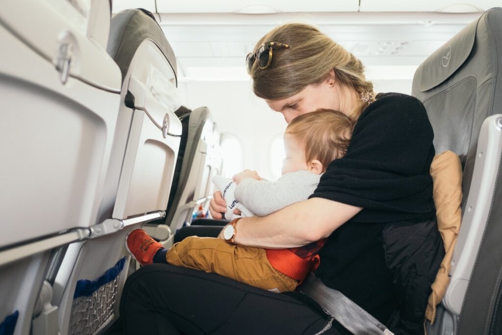 Женщина с ребёнком на руках сидит в самолёте
