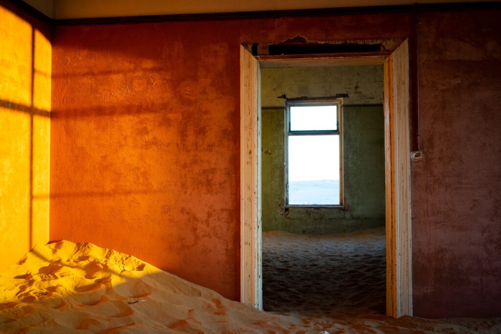 Дом с красными стенами, засыпанными песком
