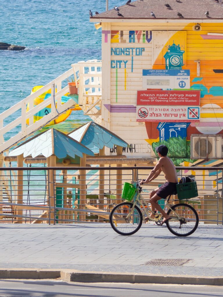 Велосипедист на пляже на фоне яркого дома