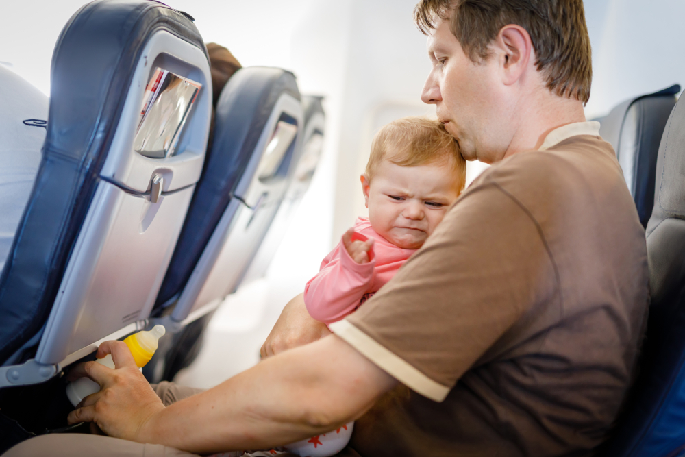 Младенец на руках у папы в самолёте