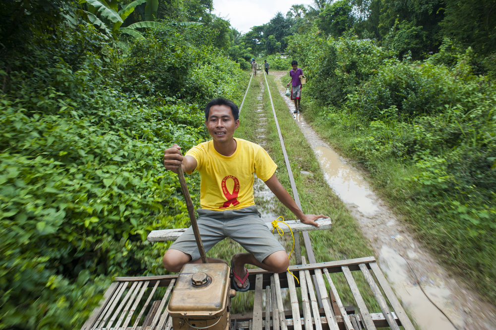 Камбоджиец ведёт бамбуковый «поезд»-вагонетку